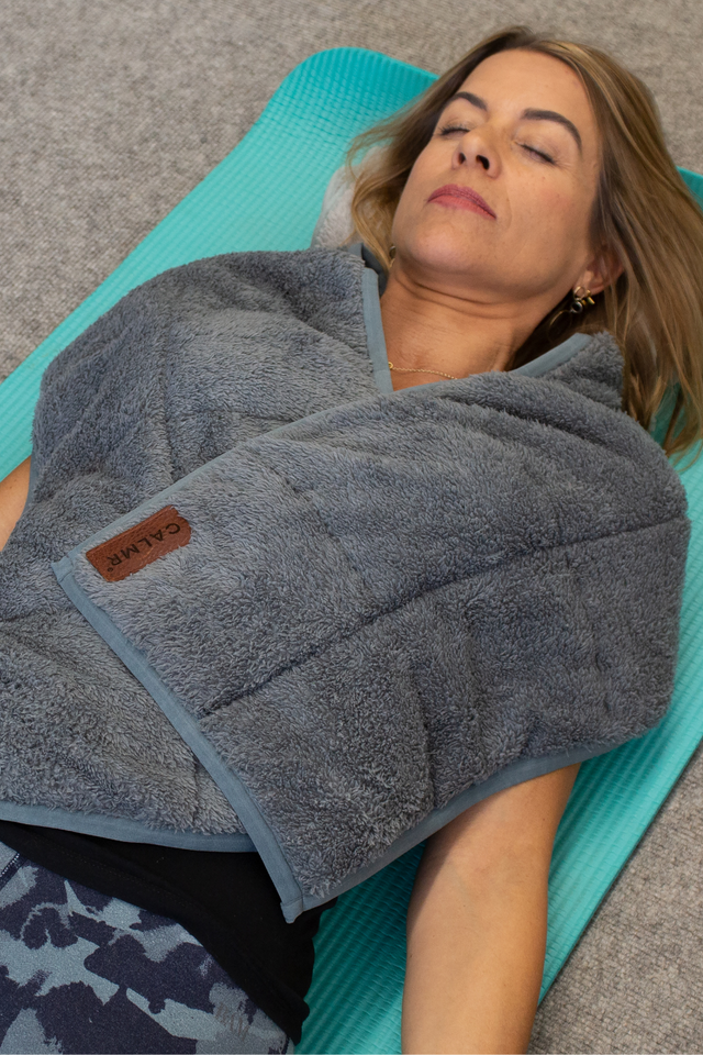 lady lying on yoga mat looking very relaxed using the weighted scarf t